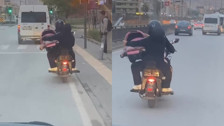 Motosiklet üzerinde bebeği pusetiyle taşıdı