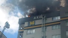 Çatıdaki alevlerin arasından itfaiye sepetine atladı