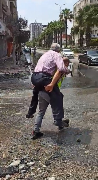 Hatay'da bir trafik polisi depremzedeyi su basan caddeden sırtında taşıyarak geçirdi - Resim : 1