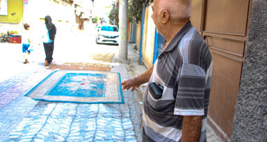 Mahalleli, onarılmayan yollara tozdan korunmak için halı serdi