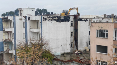 Deprem bölgesinde hayrete düşüren görüntü! İş makinası, yıkım için ağır hasarlı binanın üzerine çıkarıldı