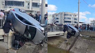 Kaza yapan araç köprünün korkuluklarında asılı kaldı