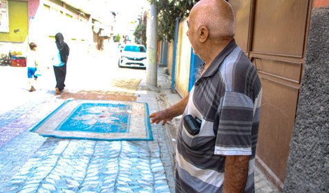 Mahalleli, onarılmayan yollara tozdan korunmak için halı serdi