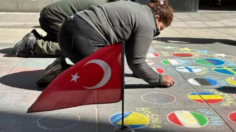 İsveç'in başkenti Stockholm'de tüm ülkelerin bayraklarını yere çizen sokak sanatçısı Sadece Türk bayrağını dalgalandırıyor! Akıllara Cumhurbaşkanı geldi