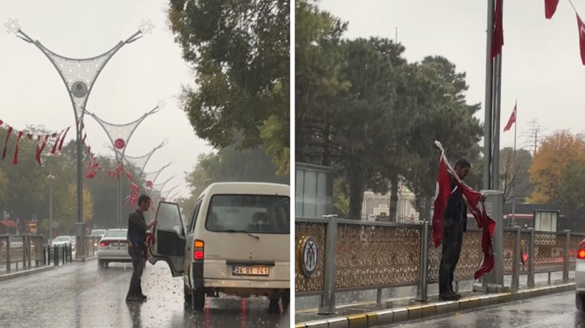 Yağmur altında yere düşen bayrakları topladı